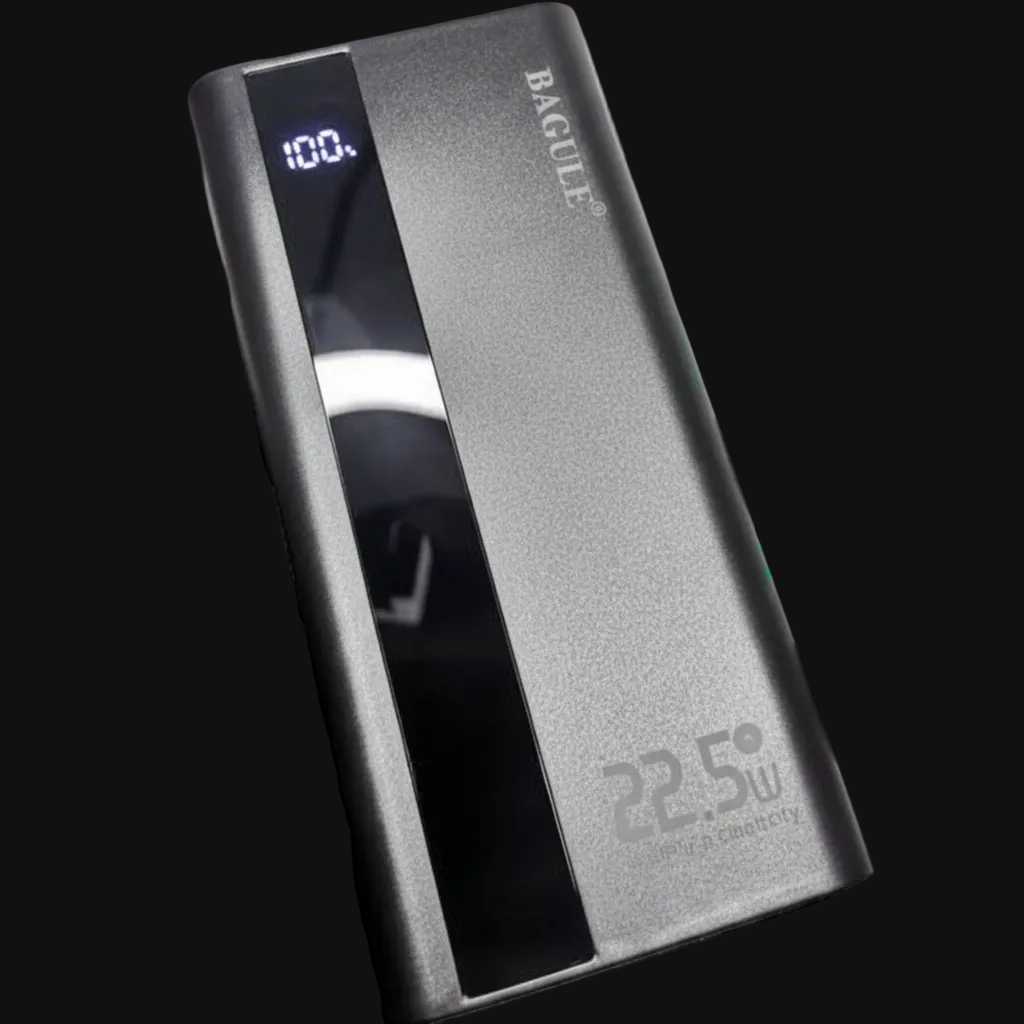 A black rectangular power bank with a glossy vertical panel, held by a black-gloved hand. The power bank has a digital display showing 100% and the brand name 'BACULITE' printed vertically near the top, with '22.