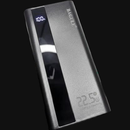 A black rectangular power bank with a glossy vertical panel, held by a black-gloved hand. The power bank has a digital display showing 100% and the brand name 'BACULITE' printed vertically near the top, with '22.